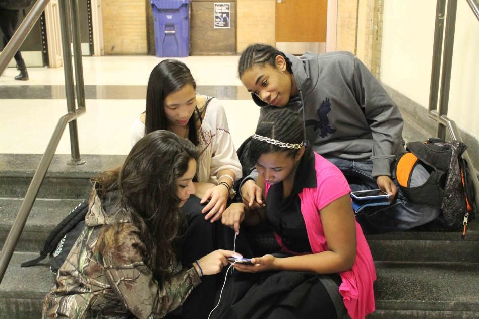 Freshmen Neftali Quiroz, Meghan Ter Molen, Gariecia Rose, and Athos Zachery check Yik-Yak on their phones.