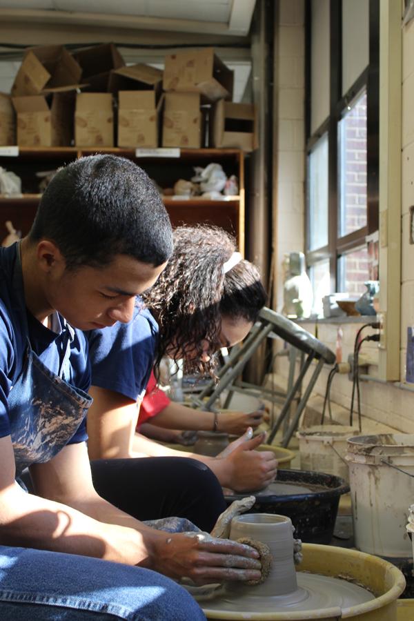 Senior Alec Austin molds a ceramic bowl.