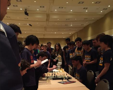 Chess team anxiously watches a match unfold