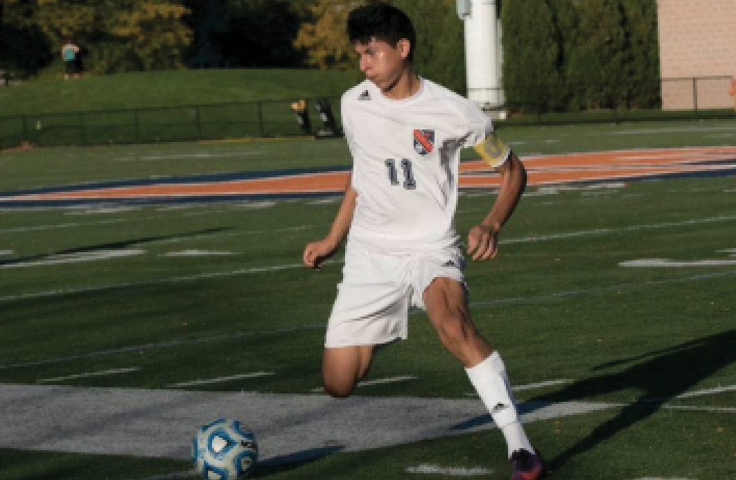 Senior Miguel Jimenez dribbles down the field against Maine East.