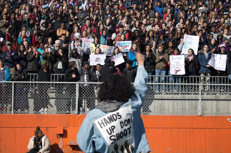 Junior Liana Wallace ends her poem about the intersection of gun violence and race by raising her fist.
