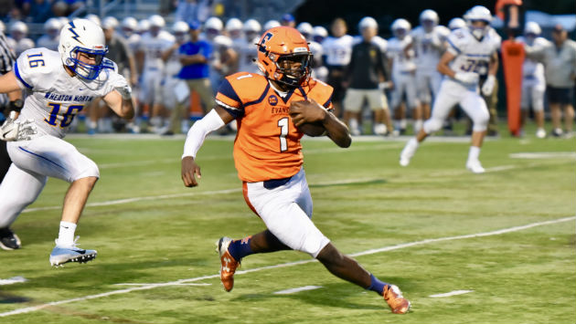 Junior Quadre Nicholson speeds past Wheaton North defenders on his way to a three touchdown night. 