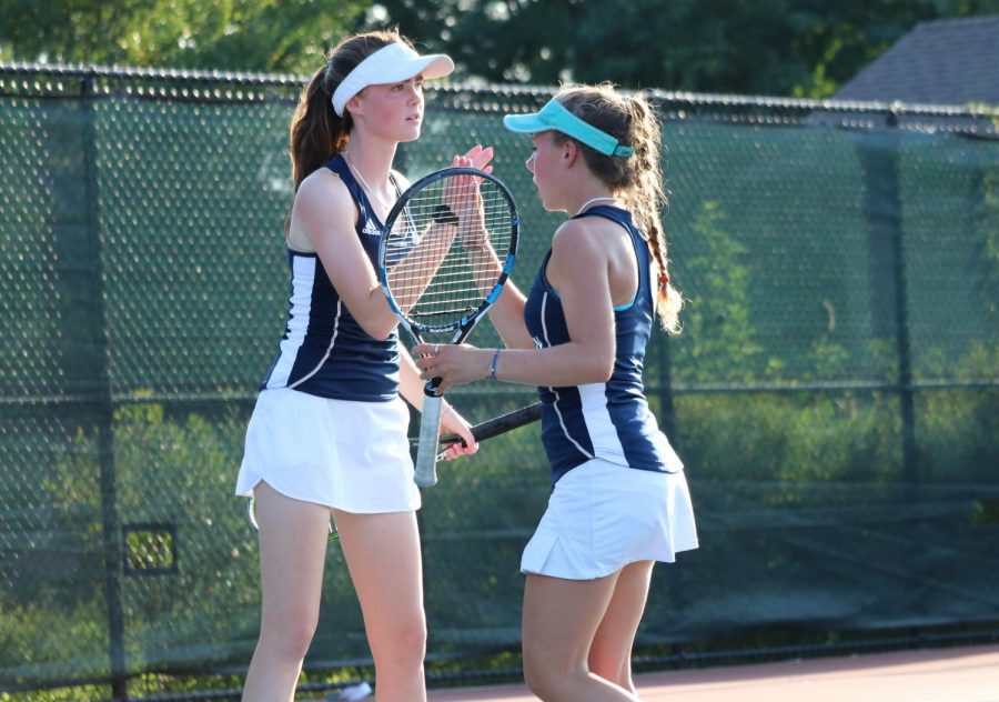 Seniors Margot Conner and Annie Hedges congratulate one another after a winning point during a regular season match versus New Trier. 