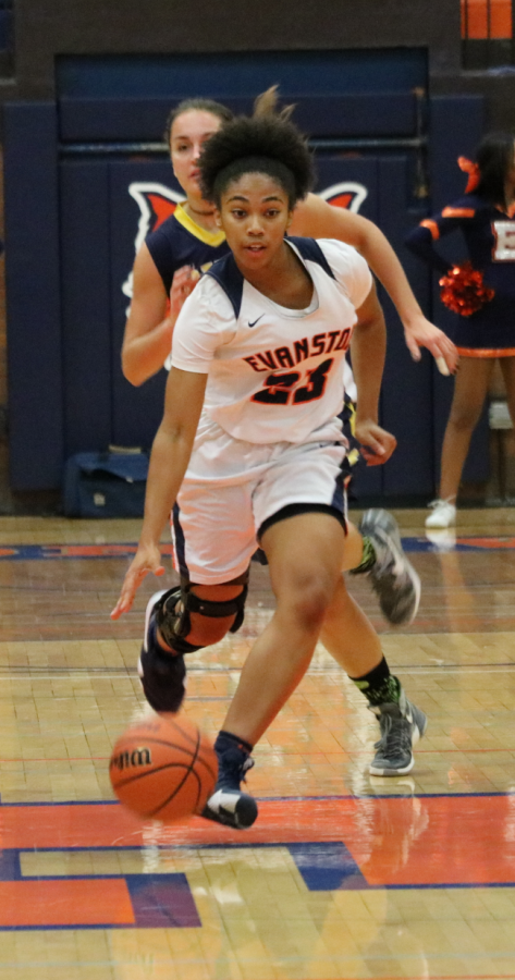 Kayla Henning, junior, dribbles down the court at Dec. 4 game against Glenbrook South. Henning recovered from an ACL injury offseason. 