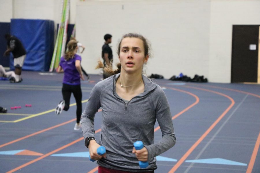 Girls cross country running in the field house.