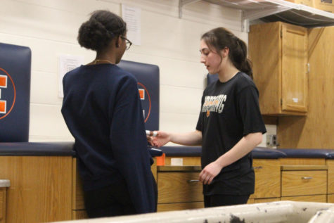 Student athletic trainers participate in a demo of proper hand taping.